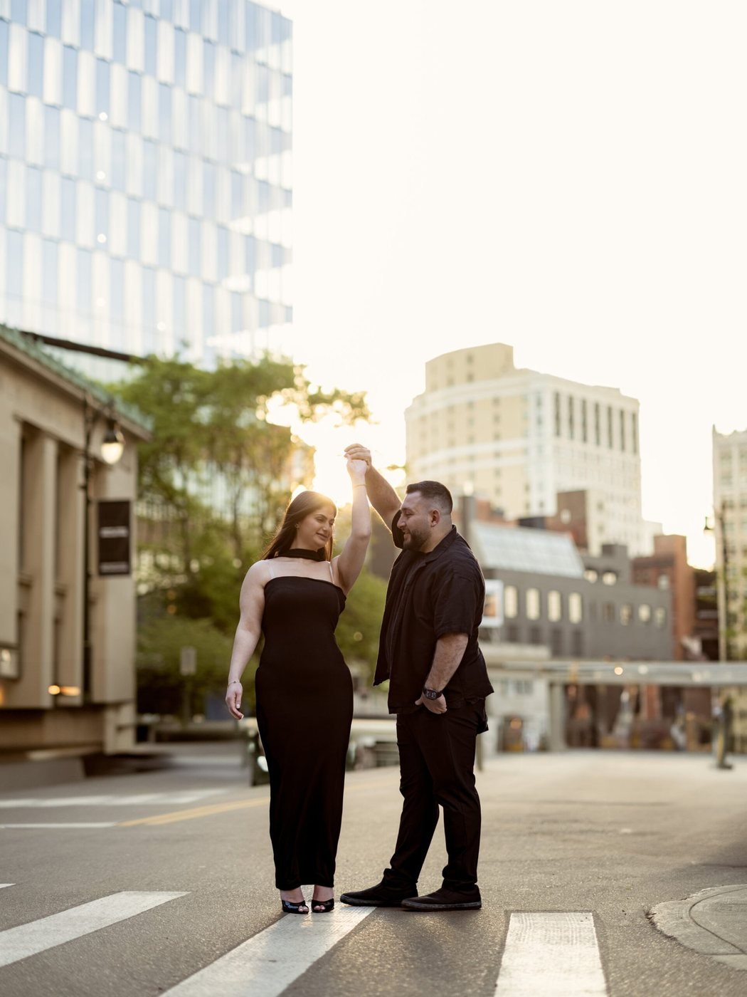 Couple dancing in the street at sunset