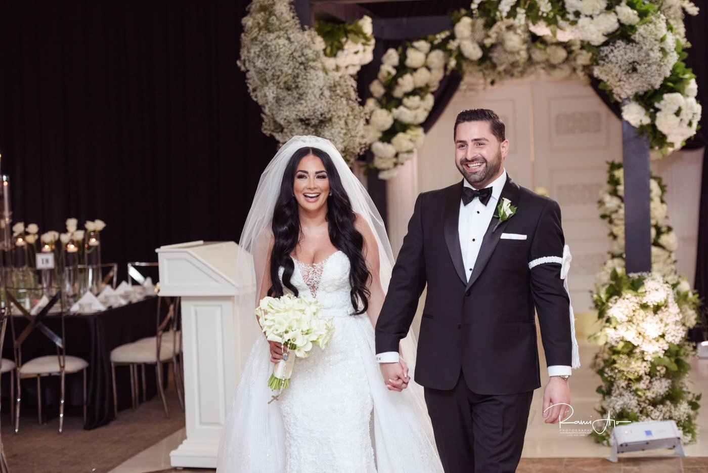Ceremony recessional beneath a floral arch