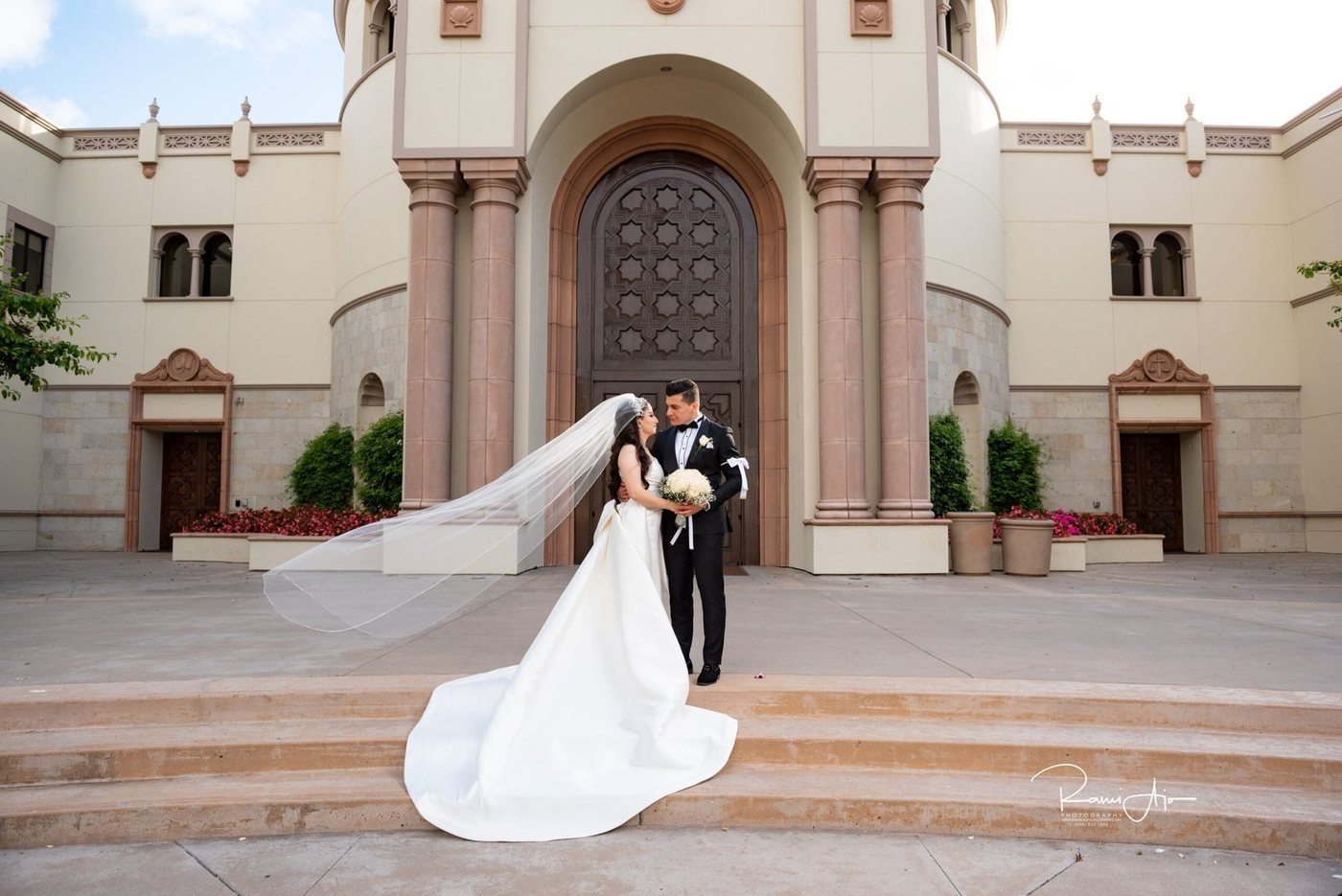 Bride and groom on the steps of a cathedral