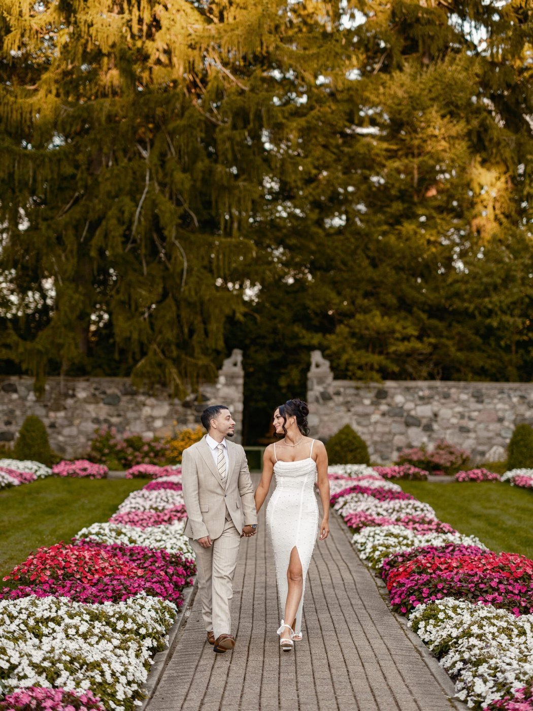 Couple walking a flower-lined garden path