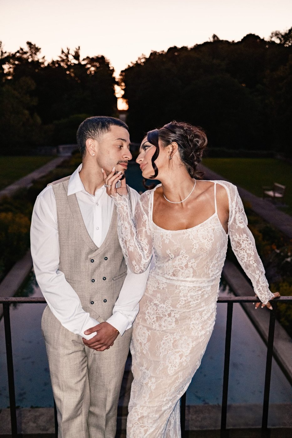 Couple at a railing against a sunset sky