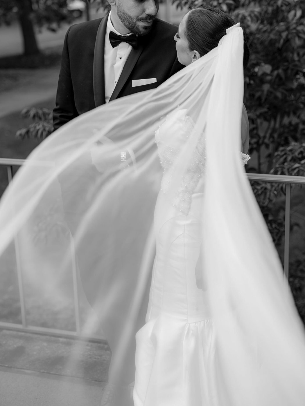 Groom lifting the bride's veil, black and white